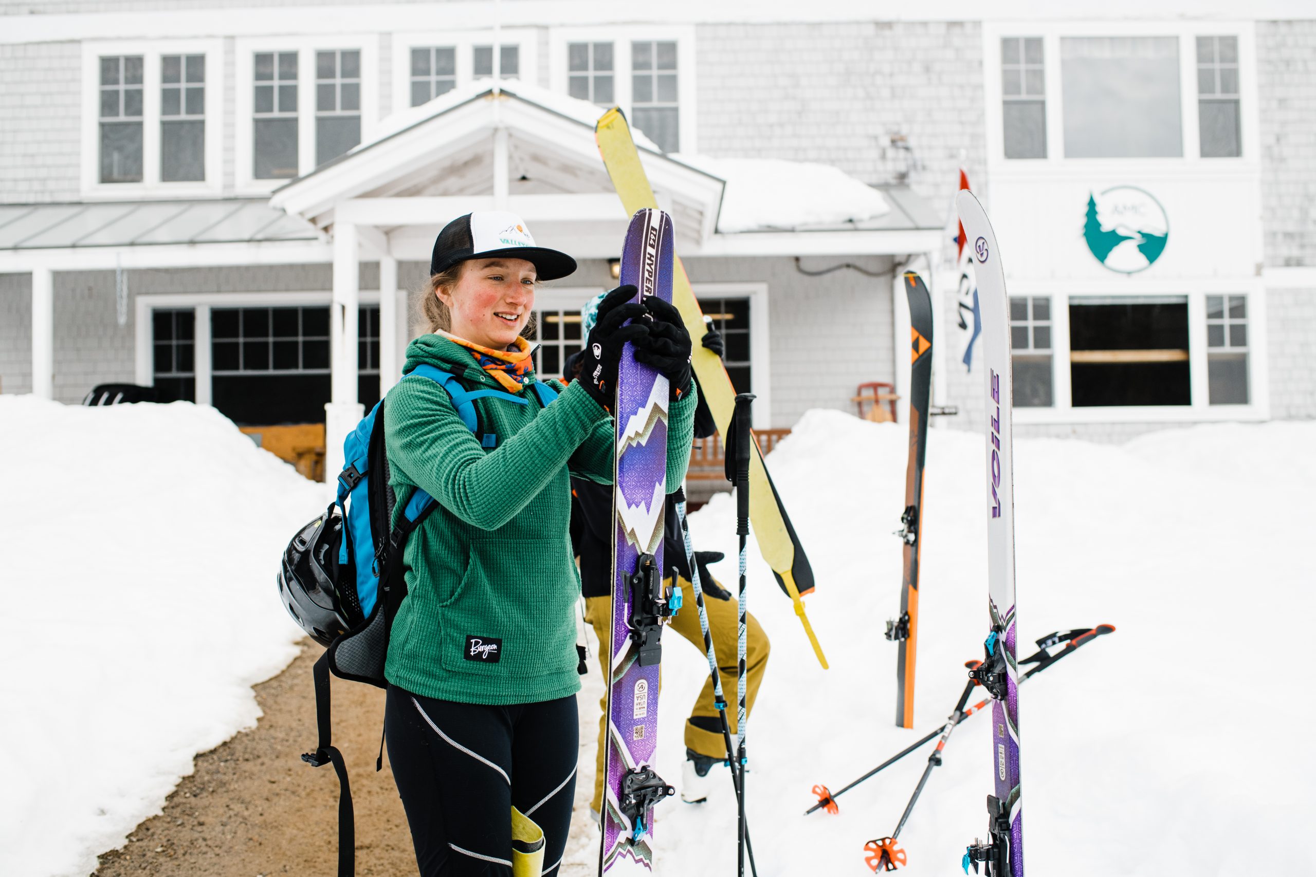 A woman prepares her skis outside of Cardigan Lodge.