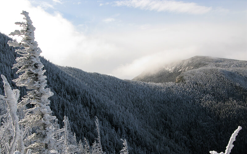 The snowy ridge of East Osceola Mountain with clouds touching the top.