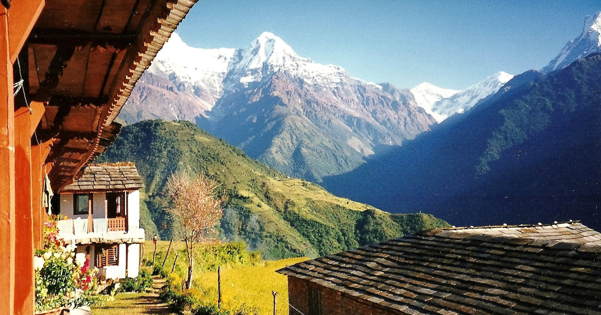 House with white-capped mountains in background.