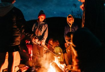 Kids roasting s'mores over a campfire.