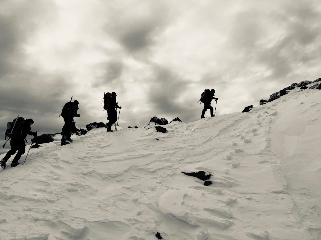 Black and white photo of hikers summiting Mt. Jefferson in the snow.