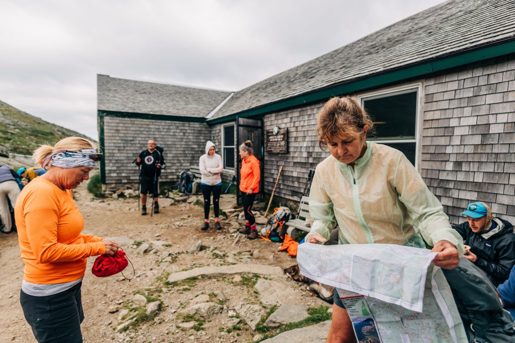 Hikers checking a map at an AMC hut before they head out.