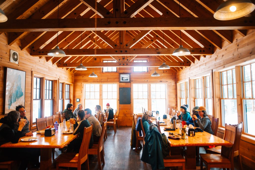 Wooden dining room with people at Gorman Chairback Lodge.