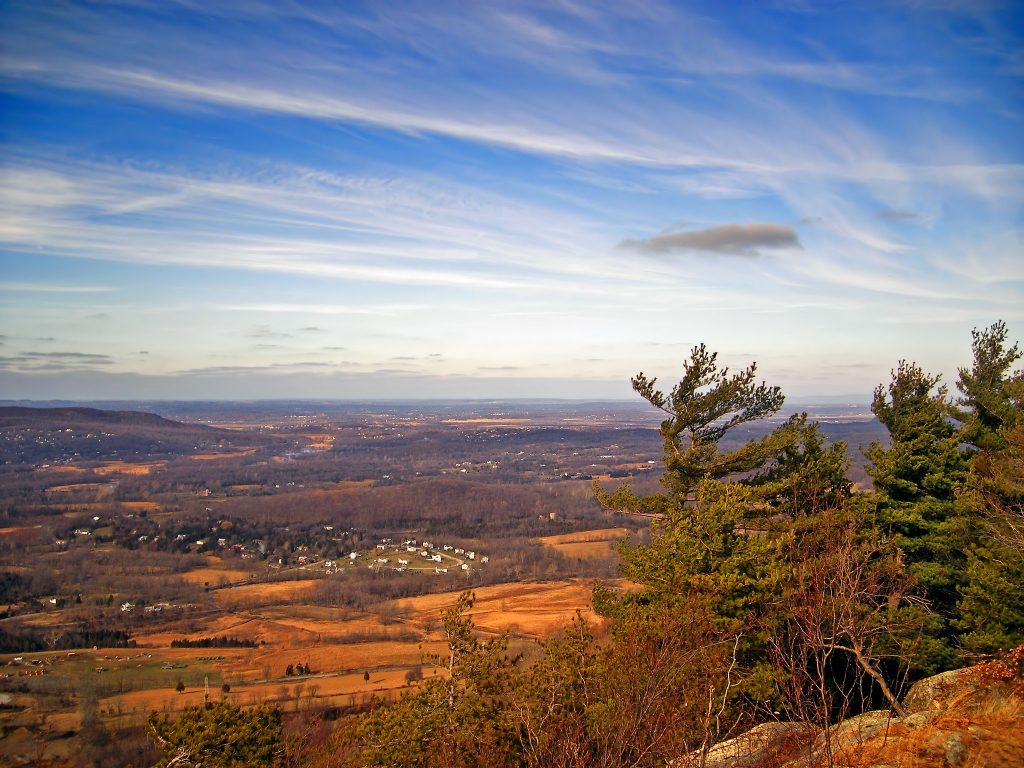 View of fields and mountains from the top of a ridge.