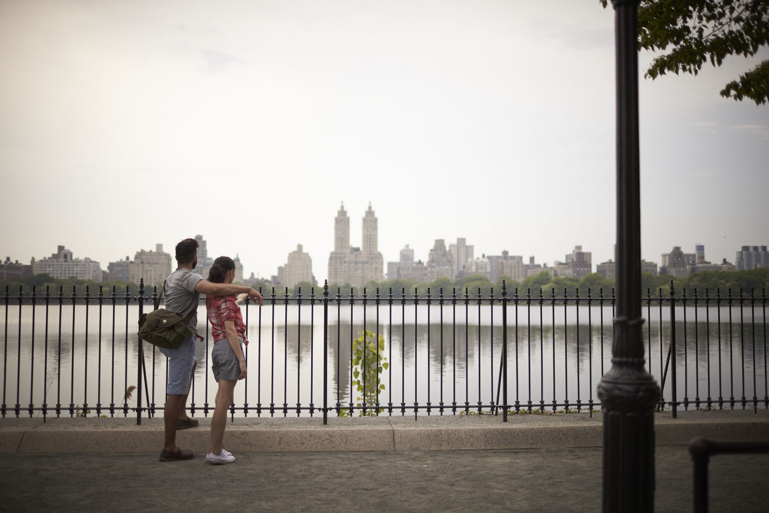A couple stands in front of the NYC skyline in Brooklyn.