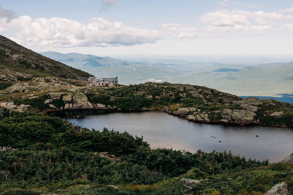 Lakes of the Clouds Hut in front of a lake.