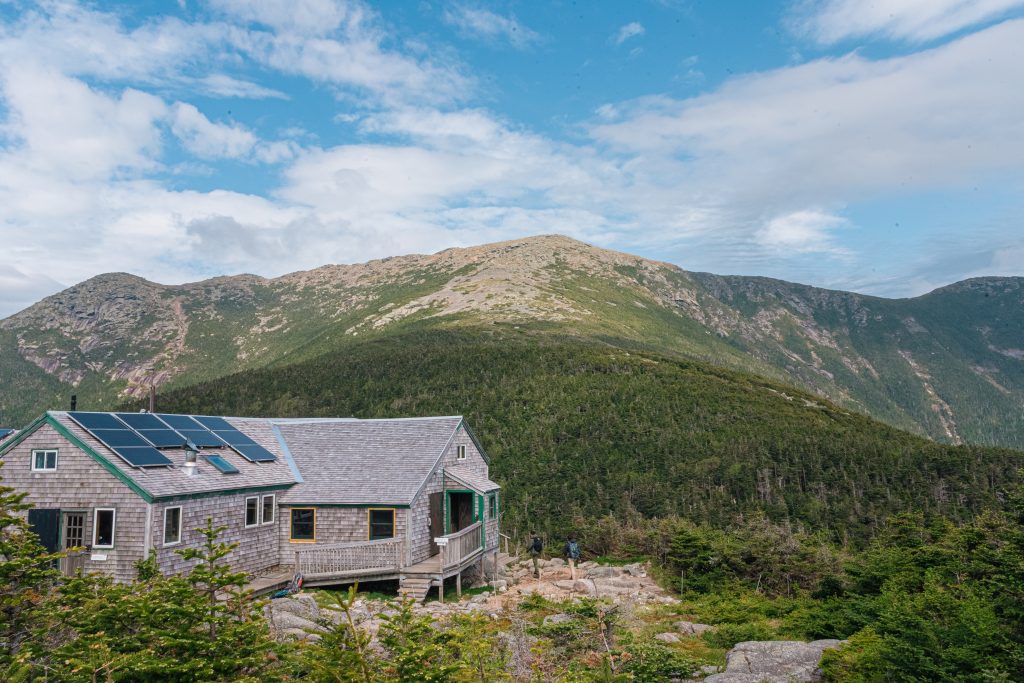 Greenleaf Hut with mountain peak in background.