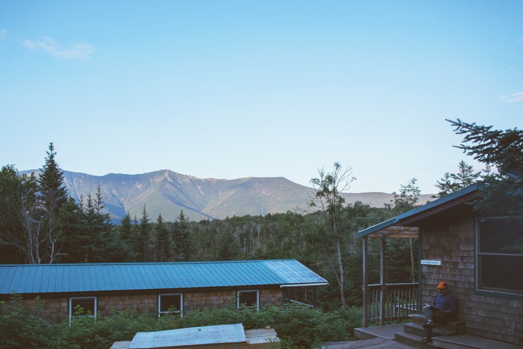 Lonesome Lake Hut with mountain ridges in the background.