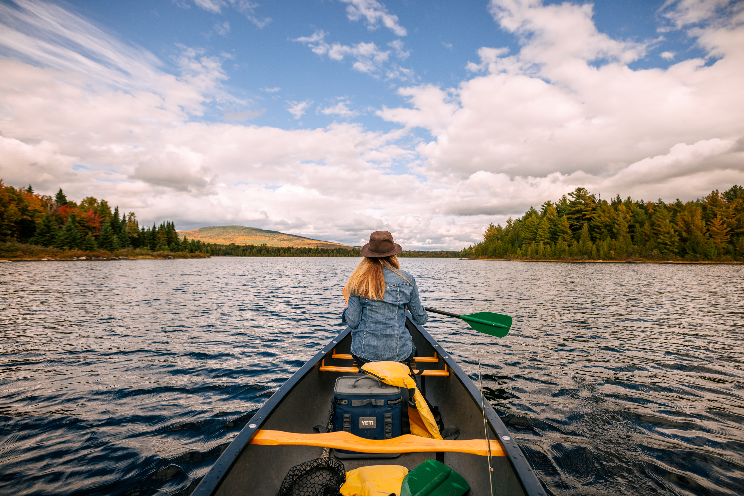 Woman on canoe framed by mountains.