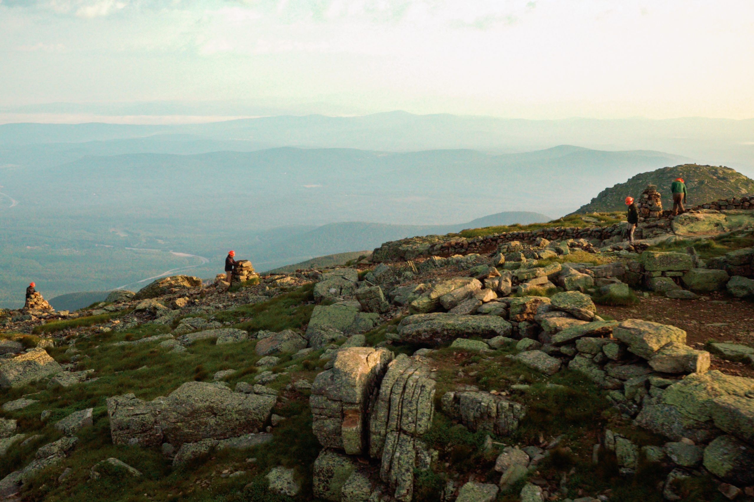 Aerial shot of the trail crew in orange helmets working on Franconia Ridge.