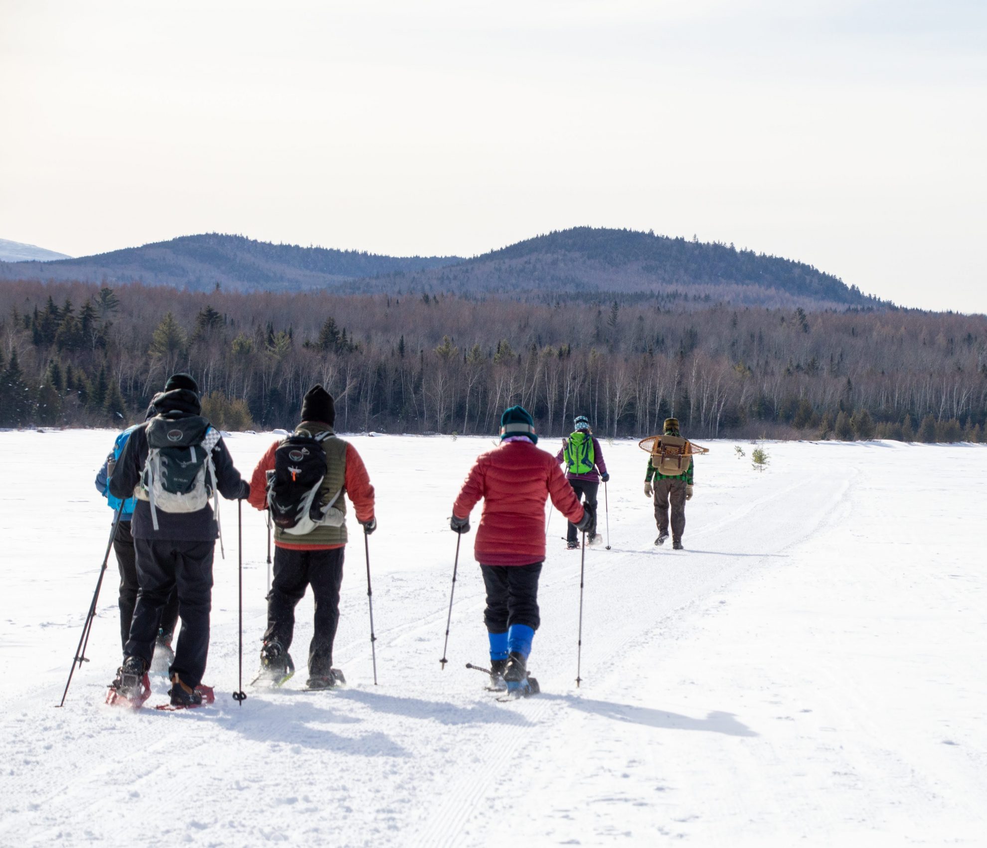 snowshoers crossing frozen lake