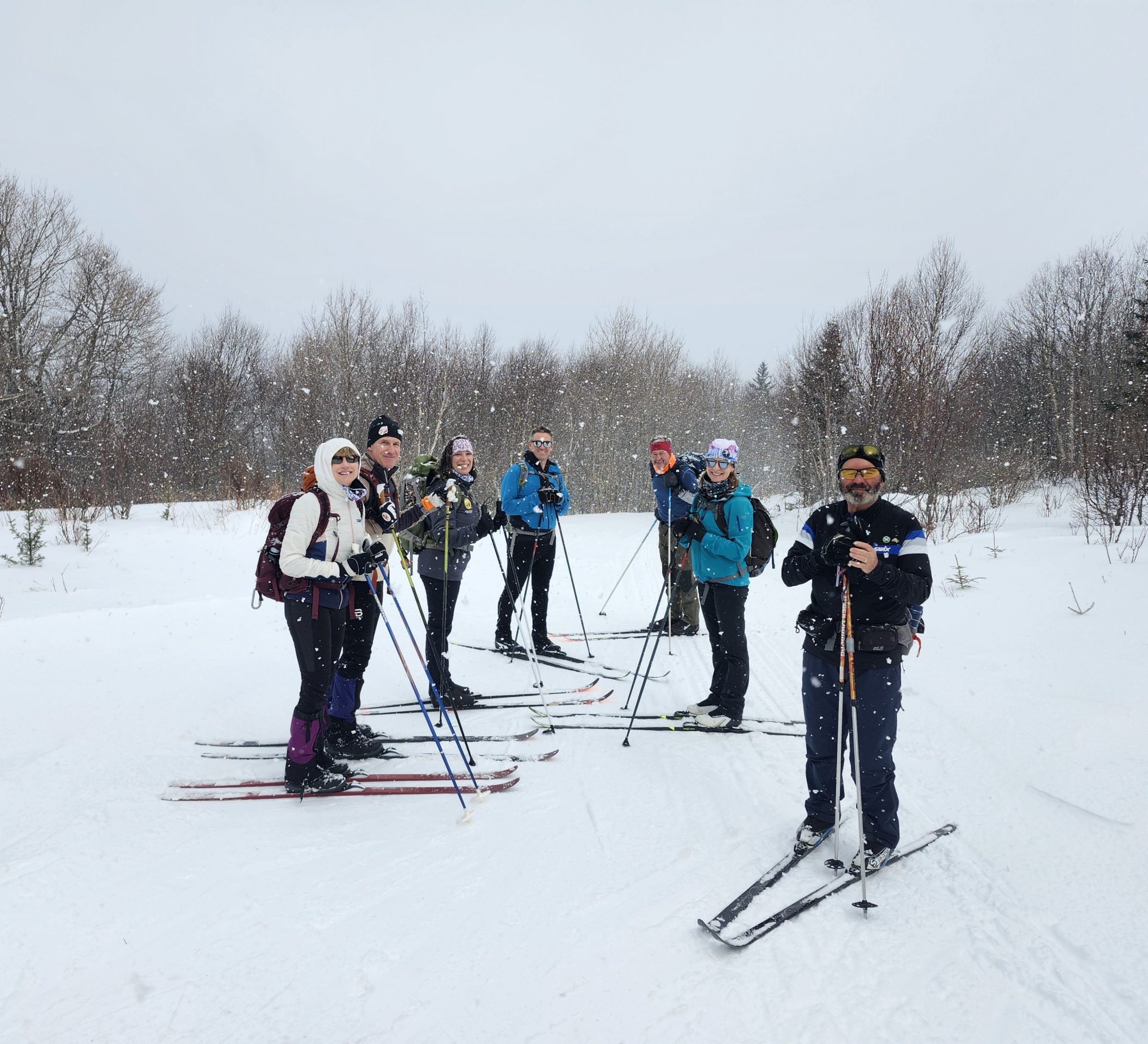 cross country skiiers posing for a photo in a snowy setting