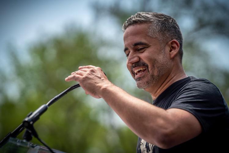 Ramon Cruz holds a microphone.