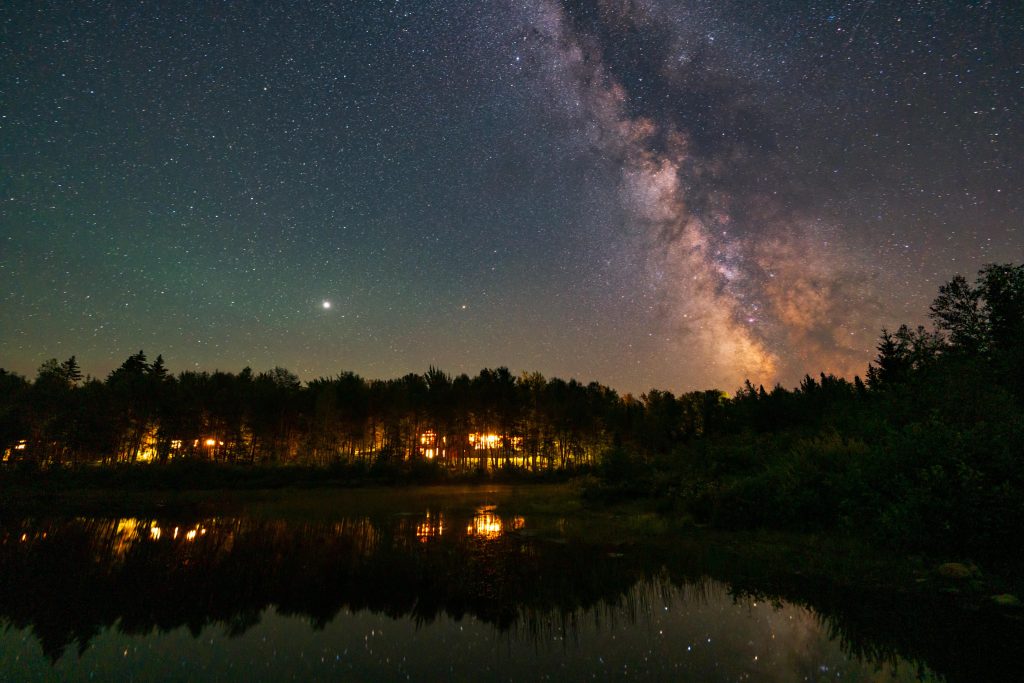 AMC Medawisla Lodge is lit up beneath a dark night sky.