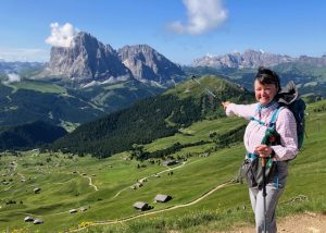 Karen Barsanti smiles and points to high granite mountains.
