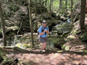 Jeanine Libby smiling on a hike in the woods.