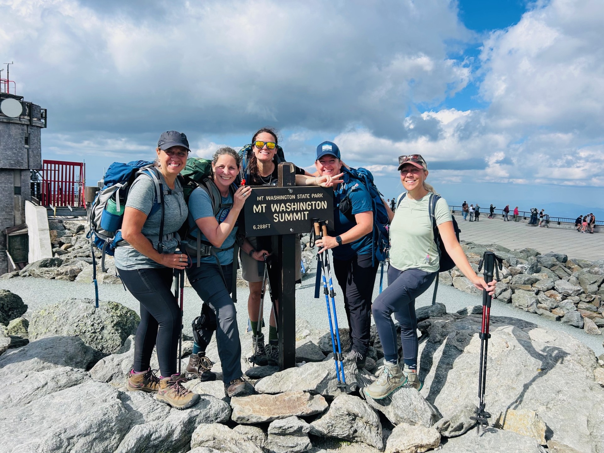 Five women smiling on top of Mount Washington
