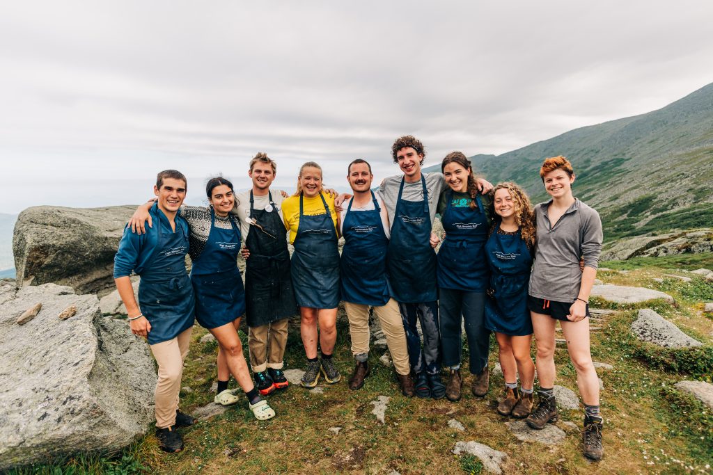 A hut Croo, smiling outside of Lakes of the Clouds.