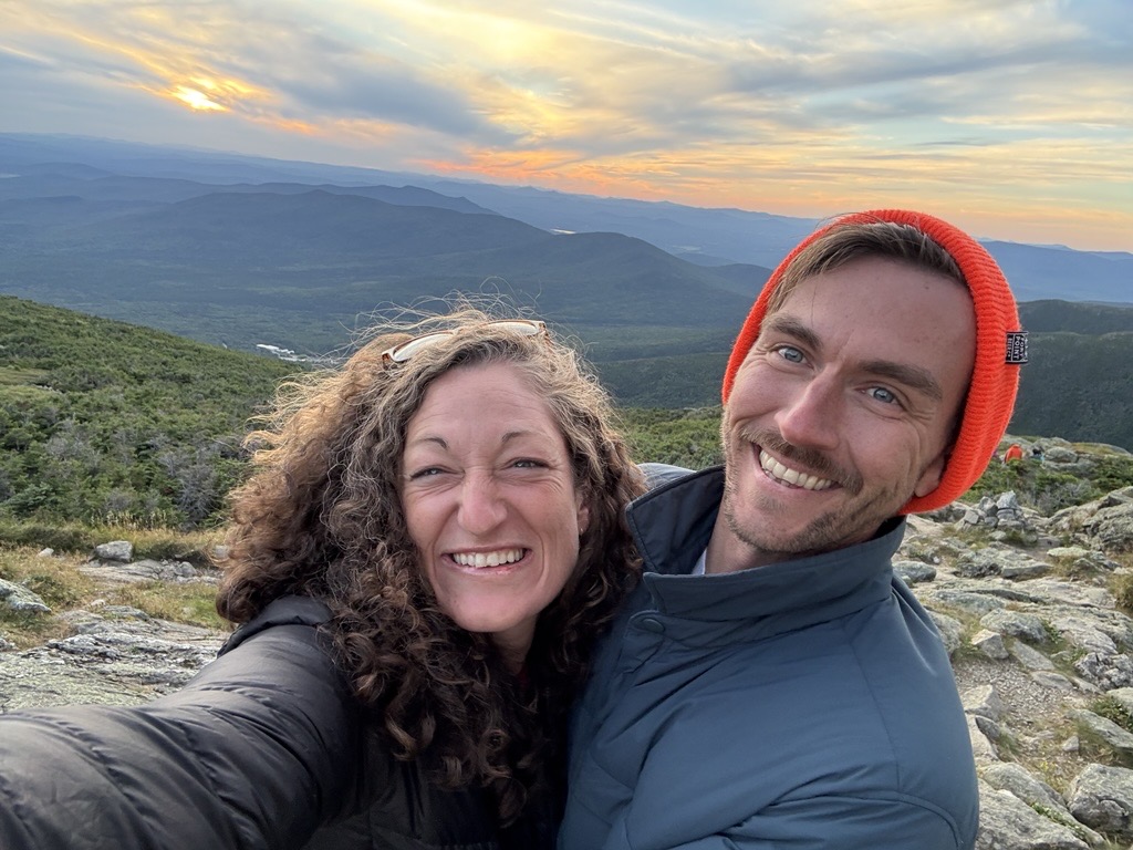 Jenny O'Connell and Josh Mitts smiling at sunset.