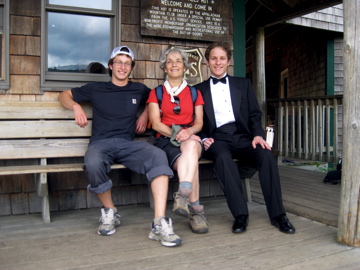 Jean Camuso and two sons sitting outside of Zealand Hut. One son is wearing a tuxedo.