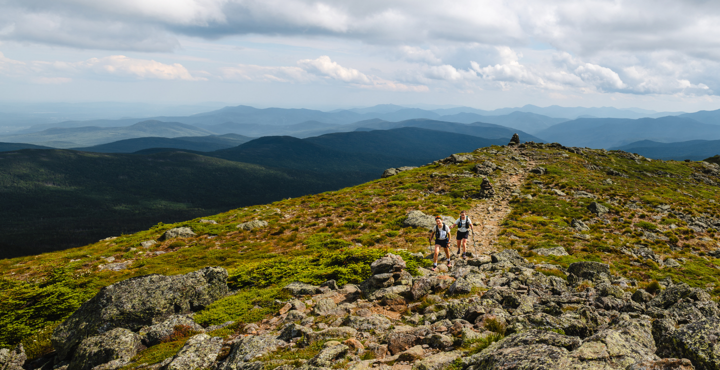 Two hikers on a ridgeline in the White Mountains